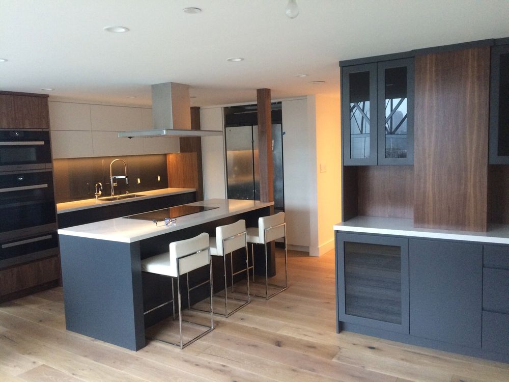 Howe Street Penthouse — custom kitchen with charcoal island, walnut cabinetry, Miele appliances and oak flooring, Vancouver